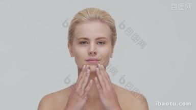 年轻、美丽、自然的金发女子应用护肤霜的工作室<strong>肖像</strong>。 面部整容、化妆品及化妆.
